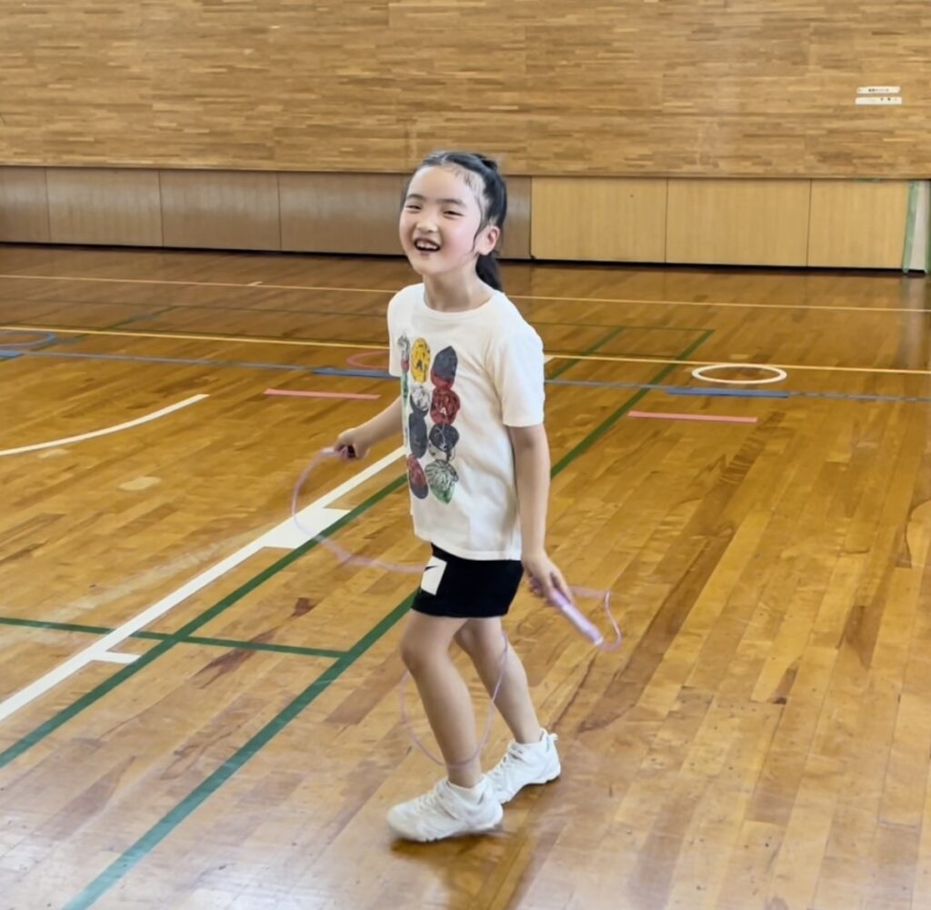 福井市教室にて、笑顔で縄跳びを練習している小学生女児の子供