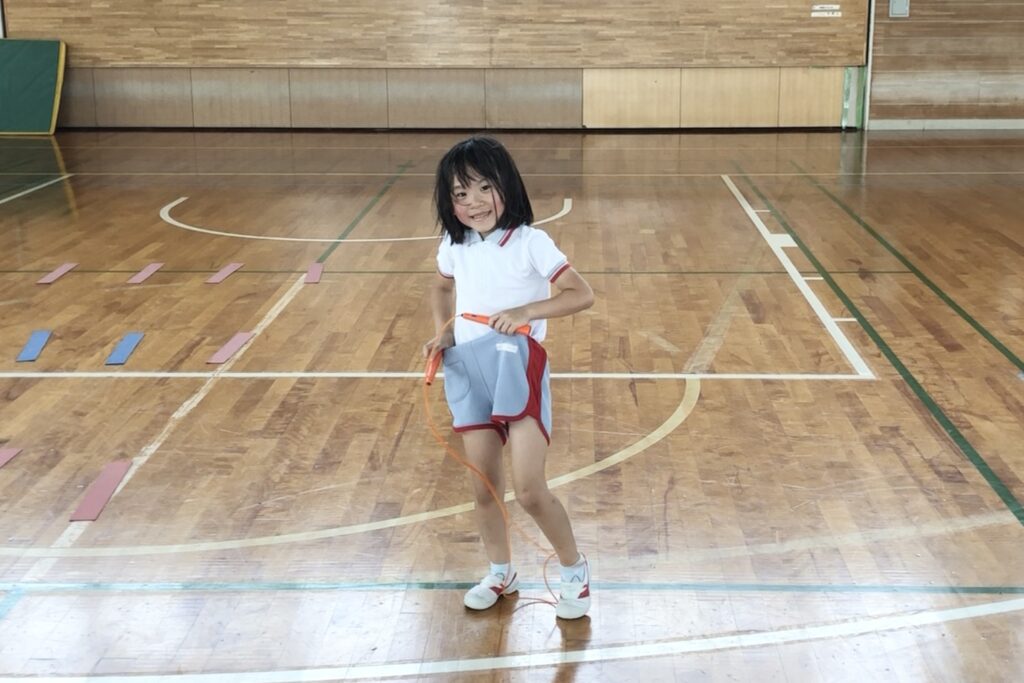福井市教室にて、笑顔で縄跳びを持つ幼児の女児