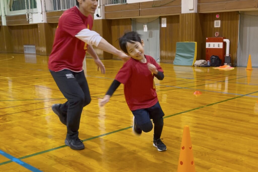 金沢市富樫教室にて、笑顔でダッシュする小学生の男の子と追いかける大久保先生