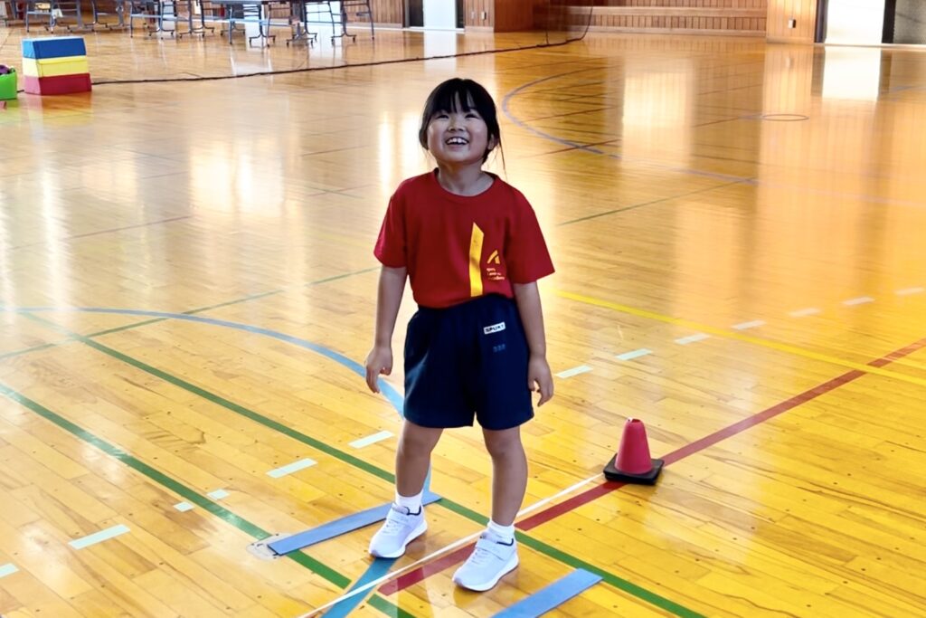 金沢市額谷教室にて、笑顔で運動神経トレーニング「ラインジャンプ」をする小学生の女の子