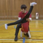 金沢市教室にて、側転にチャレンジする女児の子供と補助をする大久保先生