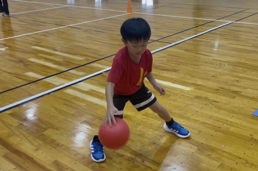 小松市の子ども体操教室でボールドリブルを練習する様子。手と足の連動を養いながらリズム感と集中力を育てる。