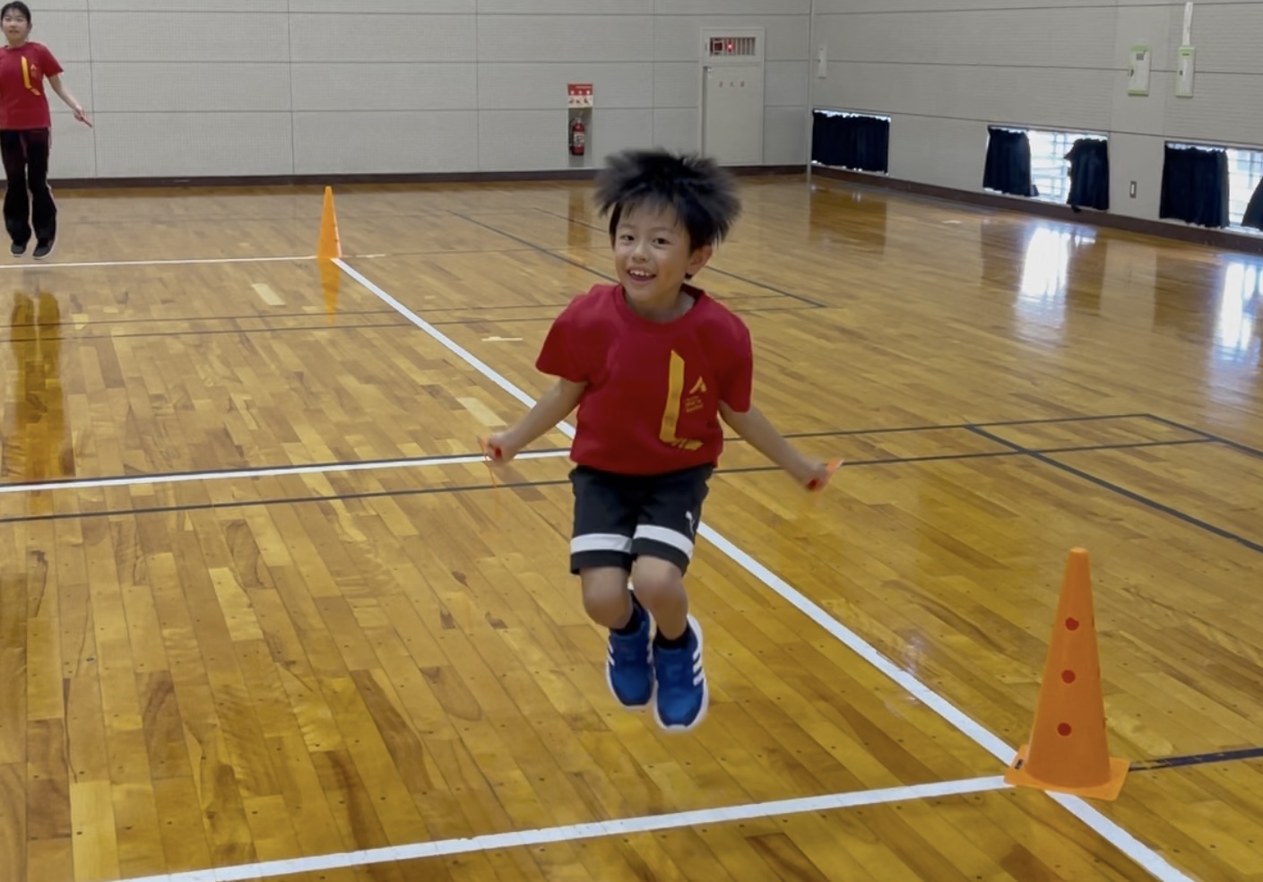 小松市の子ども体操教室で笑顔で縄跳びを跳ぶ子ども。リズム感と持久力を育てるトレーニング。