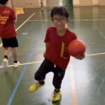 白山市教室にて、赤いボールを持って笑顔で走る男の子。体育館での運動中に楽しそうな様子を見せている。