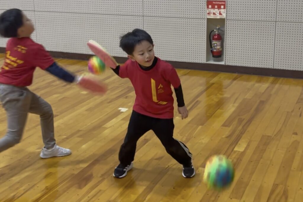 小松市の体操教室で子どもたちがラケットを使ってボール運動に取り組む様子