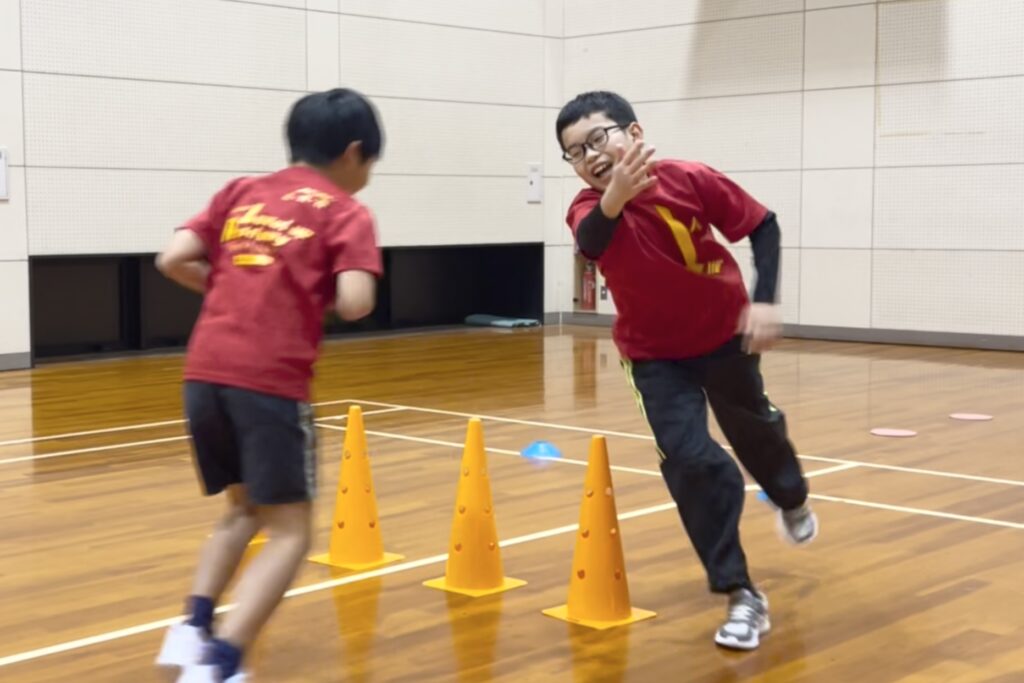 加賀市の体操教室「大久保先生のスポーツレベルアップアカデミー」にて、壁鬼ごっこを楽しみながら走る子どもたち｜運動が苦手な子も安心して取り組める大久保スポーツ教室