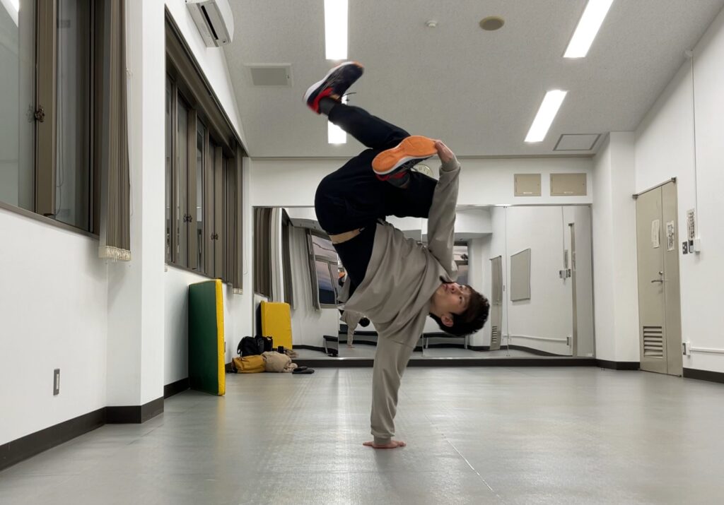 ブレイクダンスのフリーズ「変形ジョーダン」をする大久保先生