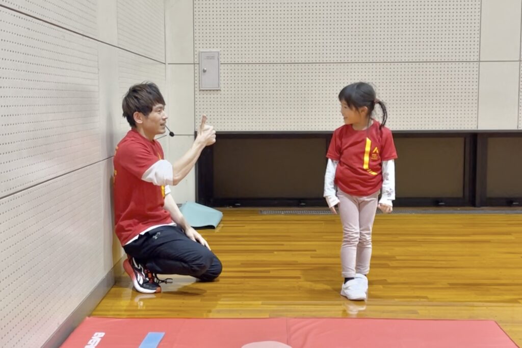 加賀市の体操教室でマット運動に成功し嬉しそうな幼児と指導する大久保先生｜できた喜びを育てるスポーツ教室