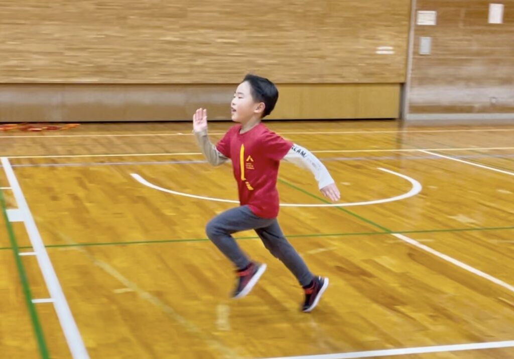 福井市教室にて、接地時間を短くするオリジナルの走り方練習「弾むランニング」を行う小学生男児の子供