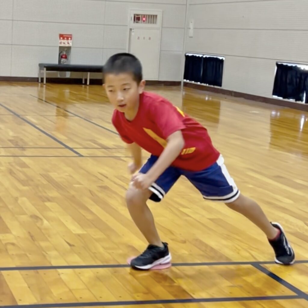 小松市の大久保スポーツ教室で反復横跳びの切り返し姿勢を練習する小学生。低重心で横方向に素早く動くアジリティトレーニングの様子。