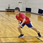 小松市の大久保スポーツ教室で反復横跳びの切り返し姿勢を練習する小学生。低重心で横方向に素早く動くアジリティトレーニングの様子。