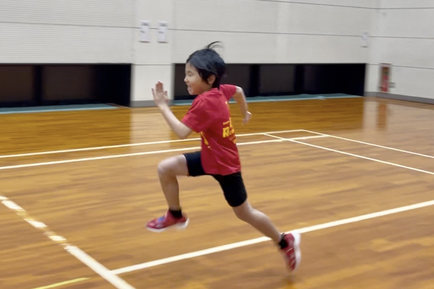 加賀市の体操教室でオリジナルのかけっこ練習を行い、正しいフォームで走る小学生の様子