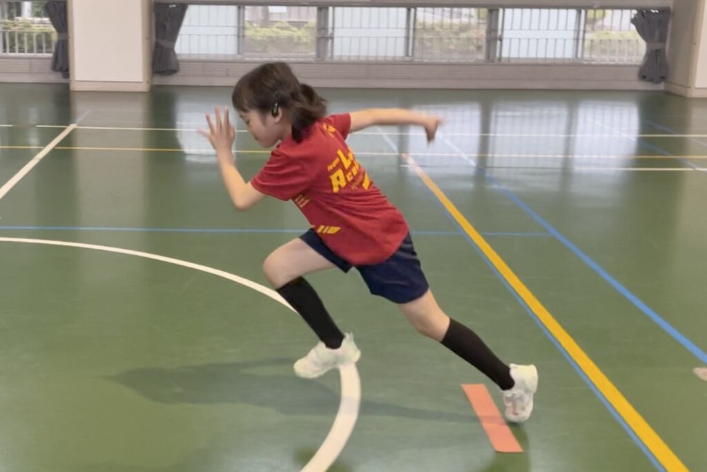 体操教室「大久保先生のスポーツレベルアップアカデミー」白山市教室にて、走り方のスタートダッシュをかっこよく行う、小学生女児の子供