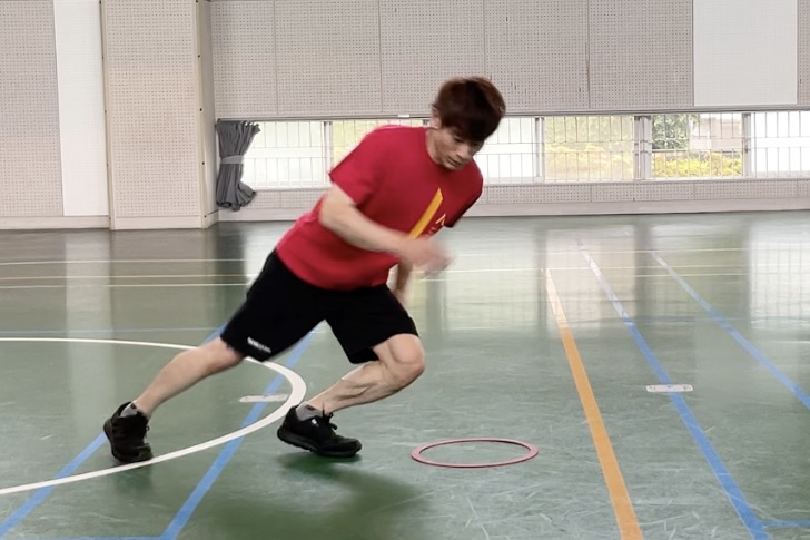 切り返しフットワークトレーニングで、横に足をステップした時の姿勢をとる大久保先生