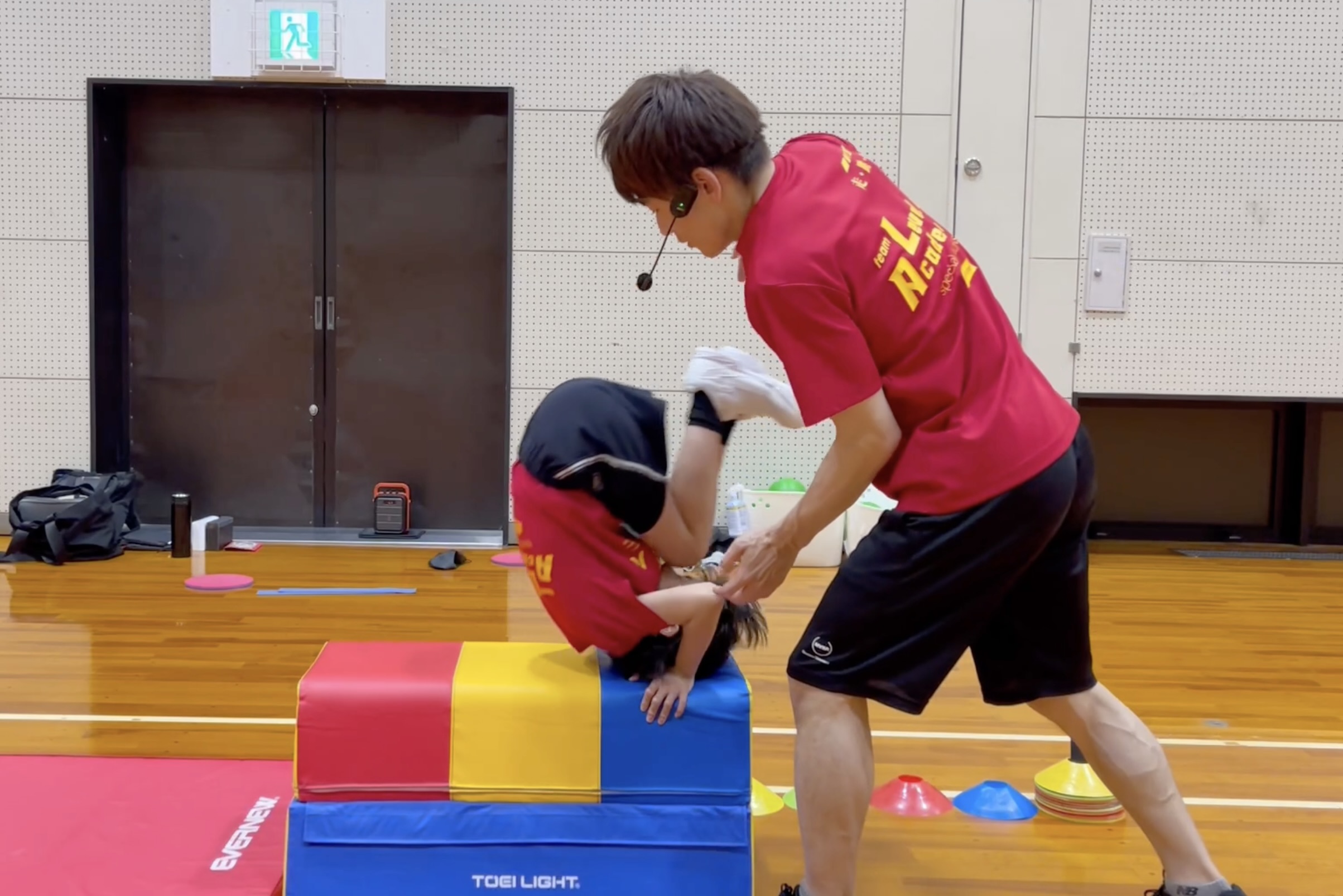 加賀市教室にて、跳び箱の台上前転にチャレンジする幼児の子供と、その子を補助する大久保先生