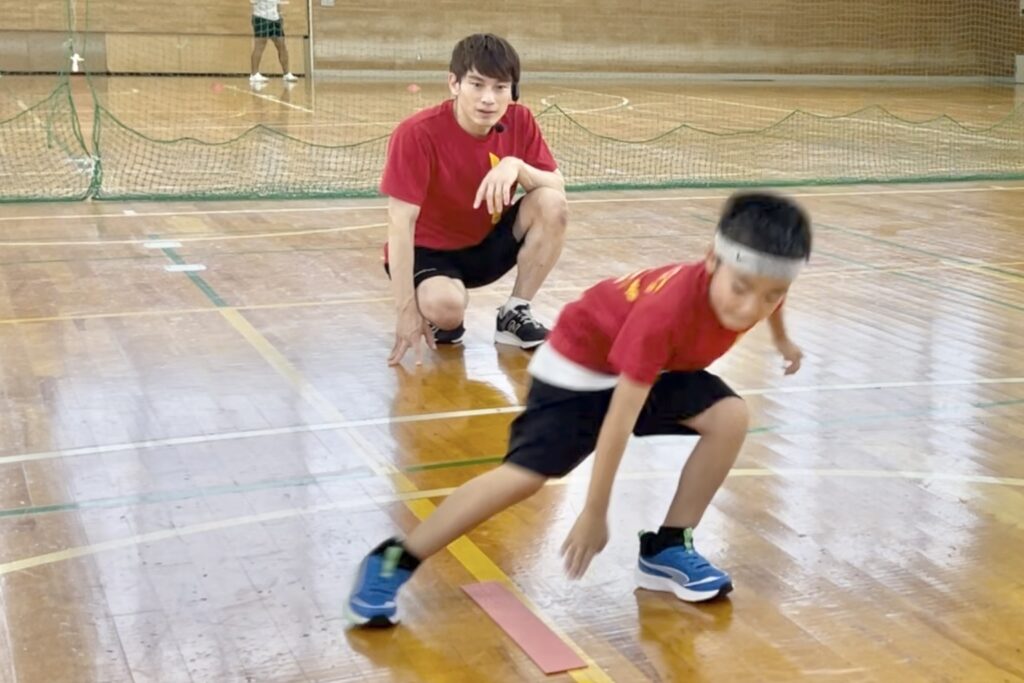 福井市教室にて、ラインタッチ切り返しトレーニングを行う男児の幼児と、それを見守る大久保先生