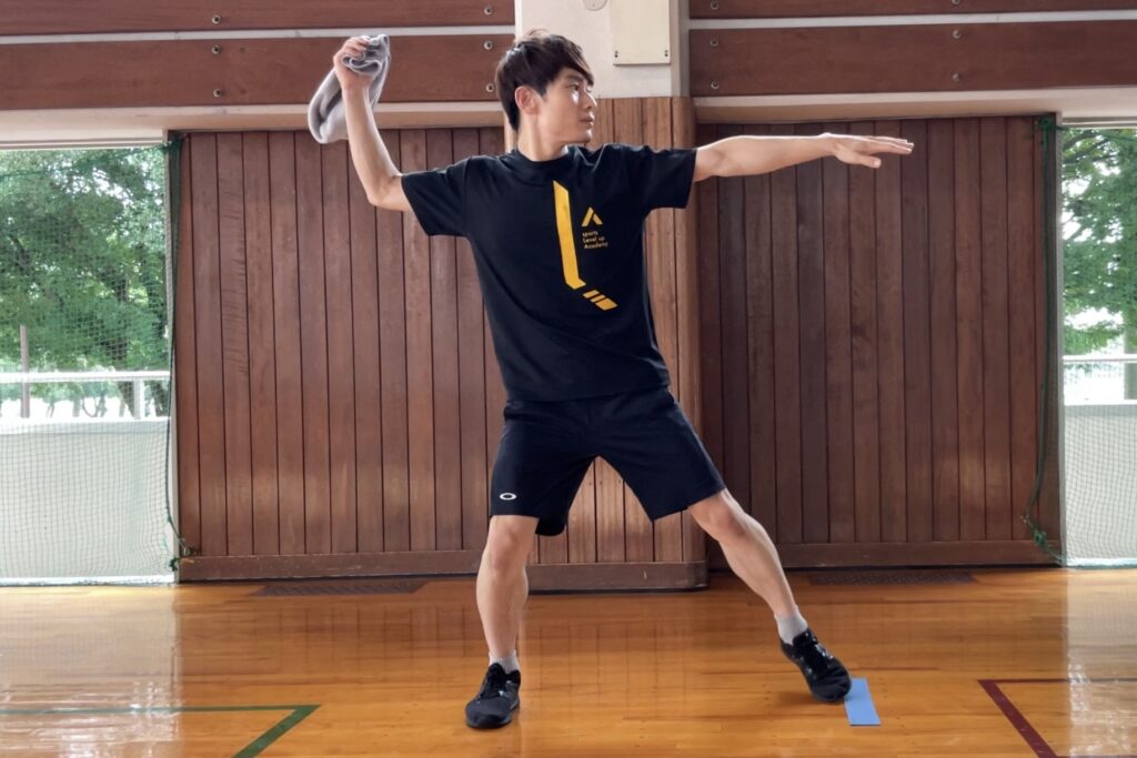 タオルを持ち、ボール投げる構えである「よーいの形」をとる大久保先生