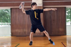 タオルを持ち、ボール投げる構えである「よーいの形」をとる大久保先生