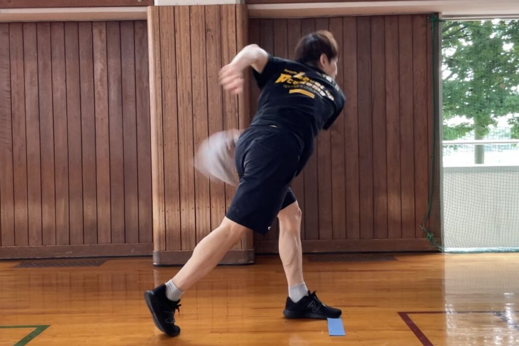 肩を入れ替えて、タオルをスイングする見本をする大久保先生